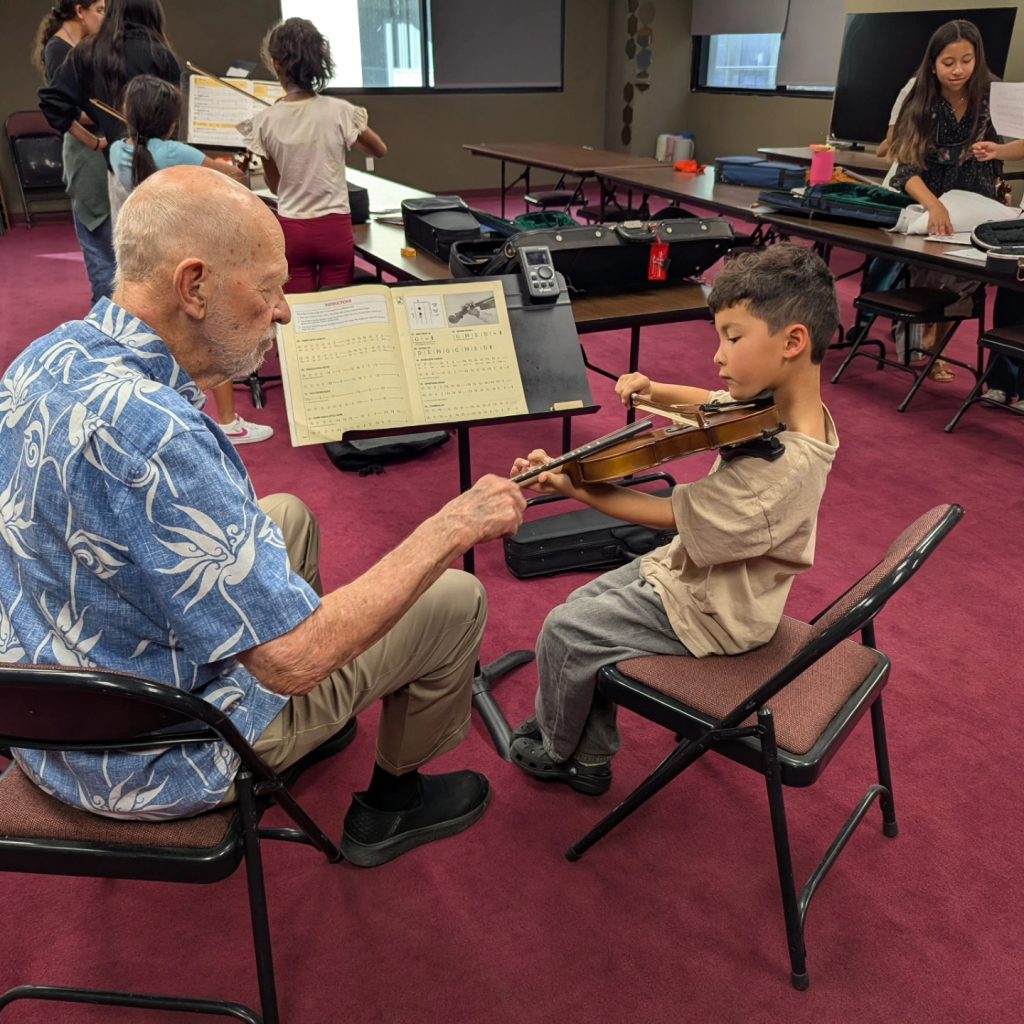 Jim Parkman, a grandpa volunteer violin teacher, sharing his love of music with young beginner Maximo at Love in Music's South Bay Class. Music truly connects generations.